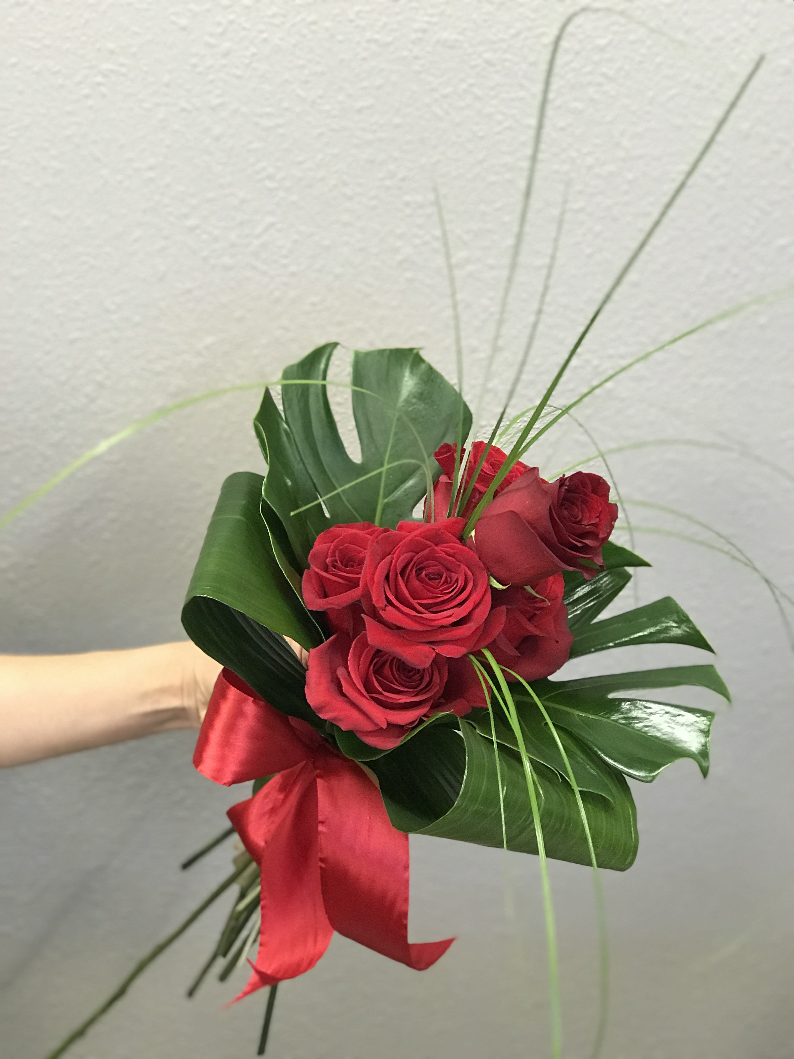 Feeling Hot Hot Hot! - Half a dozen red roses hand tied with tropical greenery is a modern, flirtatious take on this classic holiday.