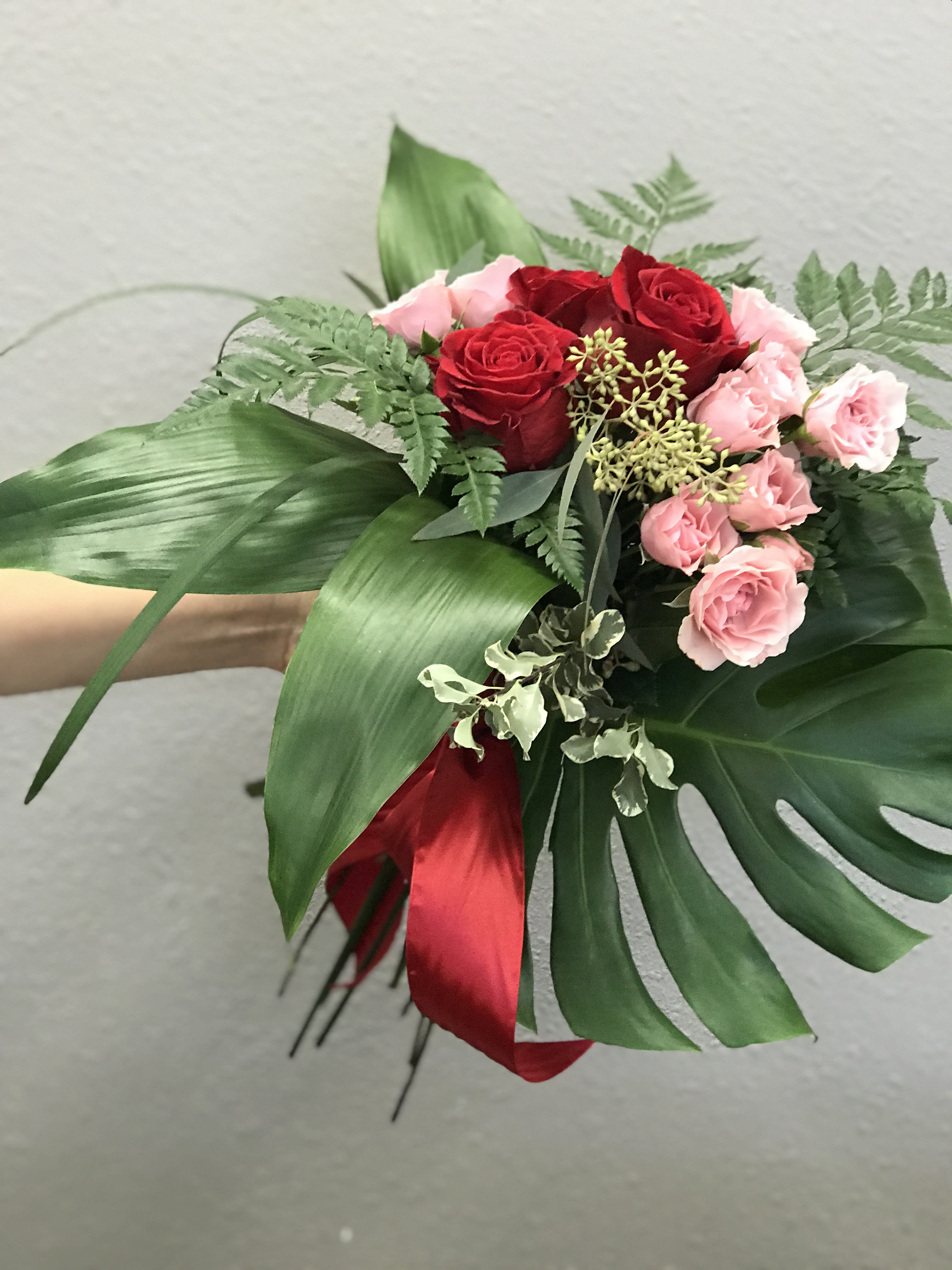The Tropical Deluxe - Celebrate this Valentines with memories of laying on a tropical beach with nothing better to do than love each other. Red and pink roses are an homage to this classic holiday with a modern twist in the tropical greens.