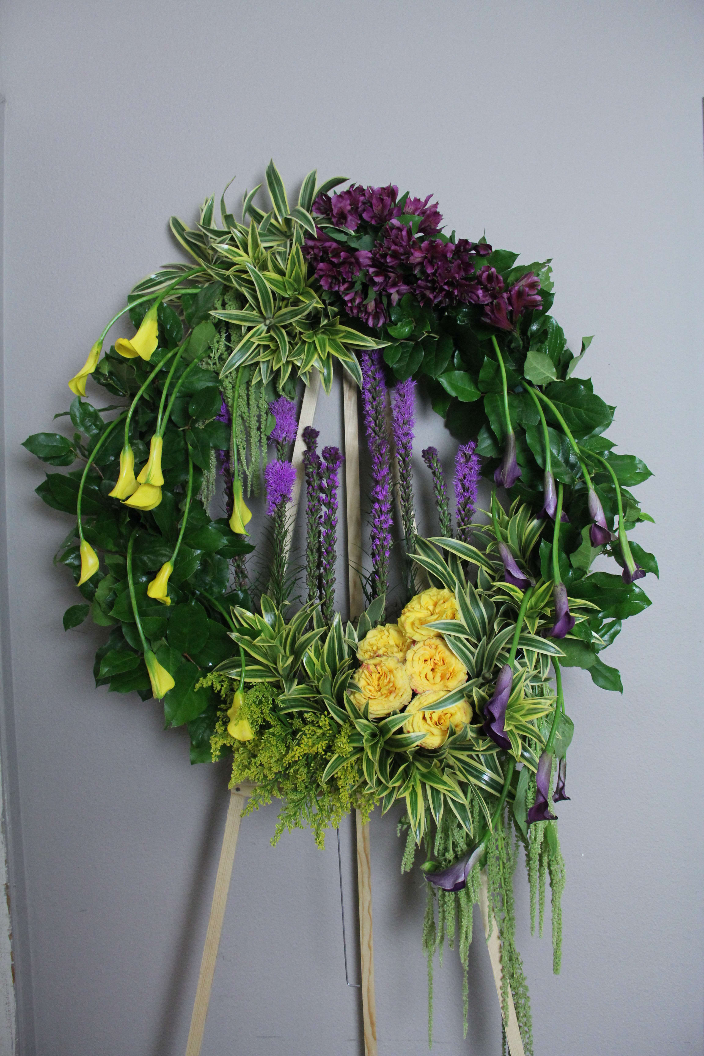 Green wreath Green wreath - Lush green wreath is decorated with beautiful fresh purple and yellow flowers.