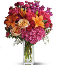 A Vibrant Sunset - What a vibrantly ravishing display! Make the world a brighter place with a wonderful array of fresh and exquisite flowers in a most delightful bouquet.