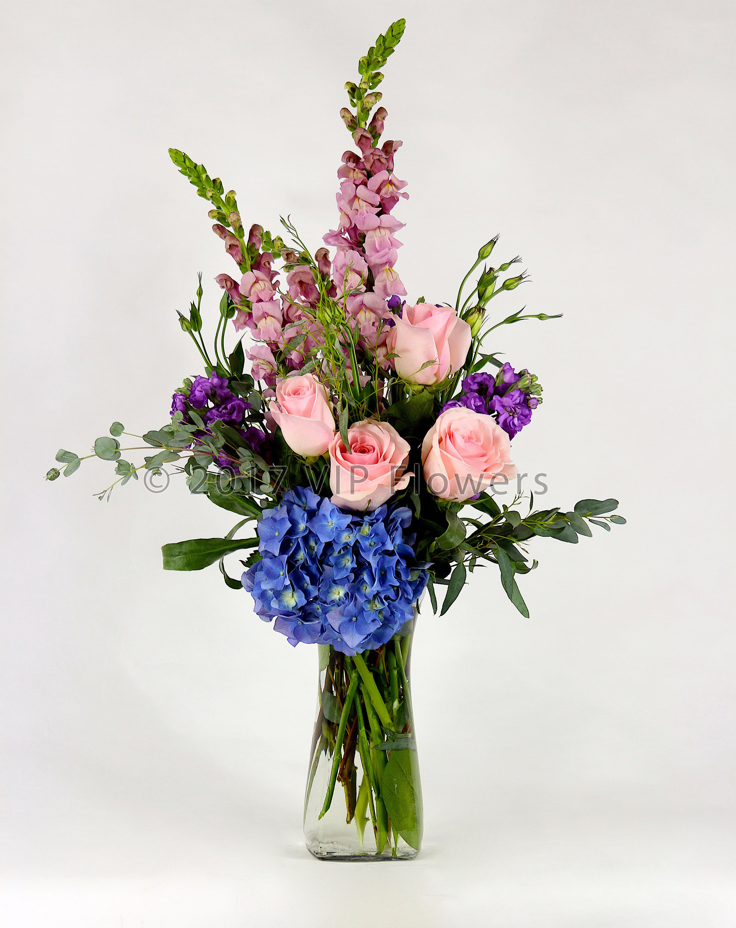 Blue Pin - Flowers Included:  Pink Roses Blue Hydrangea Pink Snapdragons Purple Stock Seasonal Greens       Substitutions may be necessary to ensure your arrangement or specialty gift is delivered in a timely manner. The utmost care and attention is given to your order to ensure that it is as similar as possible to the requested item (Please note that some flowers and colors may vary due to seasonality.)