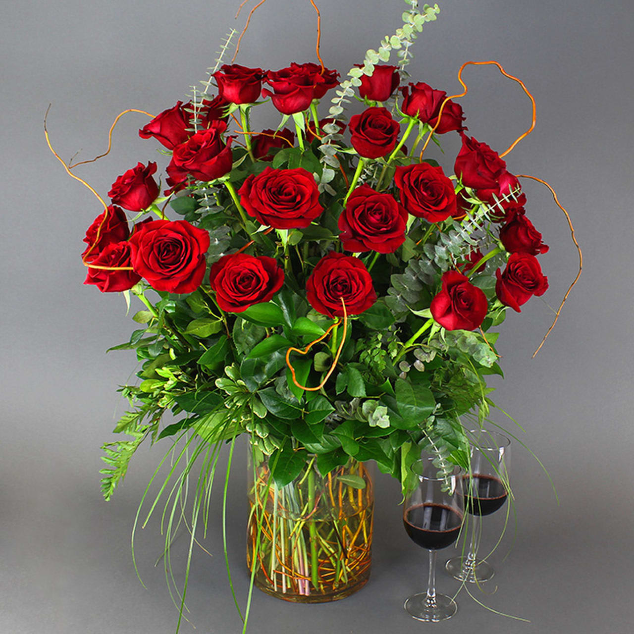 RED ROSES ARRANGED IN A VASE WITH CURLY WILLOW AND EUCLYPTUS in West