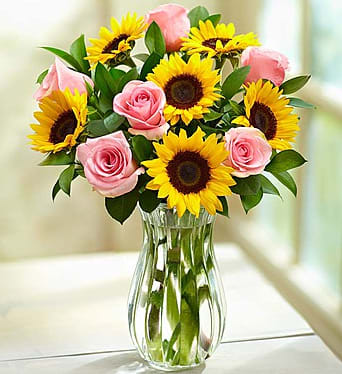 Ray of Sunshine - Sometimes a burst of sunshine can make all the difference in somebody’s day. That’s why we’ve created this charming bouquet, gathered fresh with golden sunflowers and sweet pink roses. Our bright, delightful blooms will bring a smile to that special person in your life…and that’s the most important gift of all.