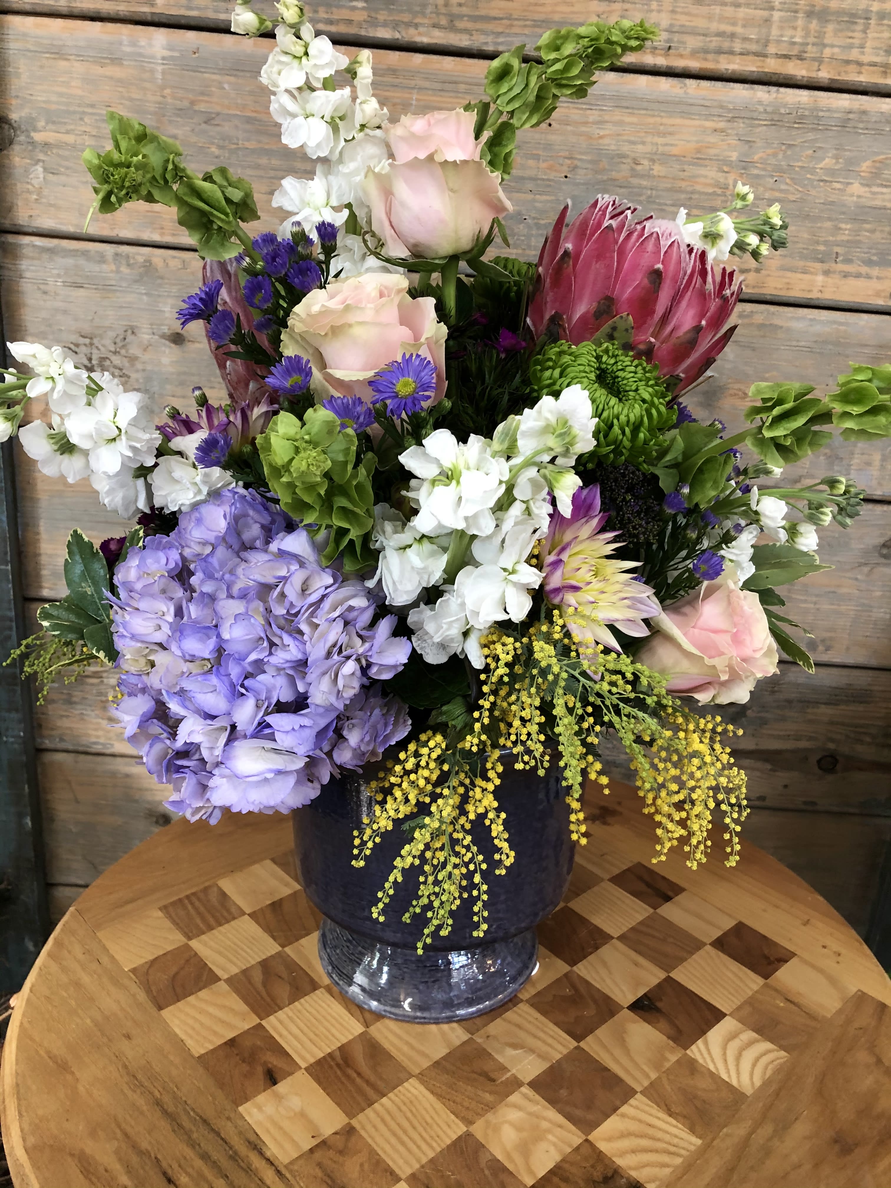Pastel Design - A beautiful eye catching design. A vase full of seasonal fresh blooms and interesting greens.