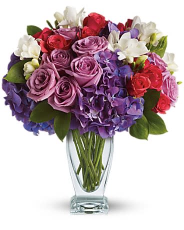 Telelfora's Rhapsody In Purple Telelfora's Rhapsody In Purple - She'll wax poetic over this posh purple presentation! A unique mix of colors and textures make this a stunning gift for any occasion and anyone - especially those who prefer purple! Rich purple roses and hydrangea are playfully contrasted with hot pink roses and fragrant white freesia in an angular glass vase.
