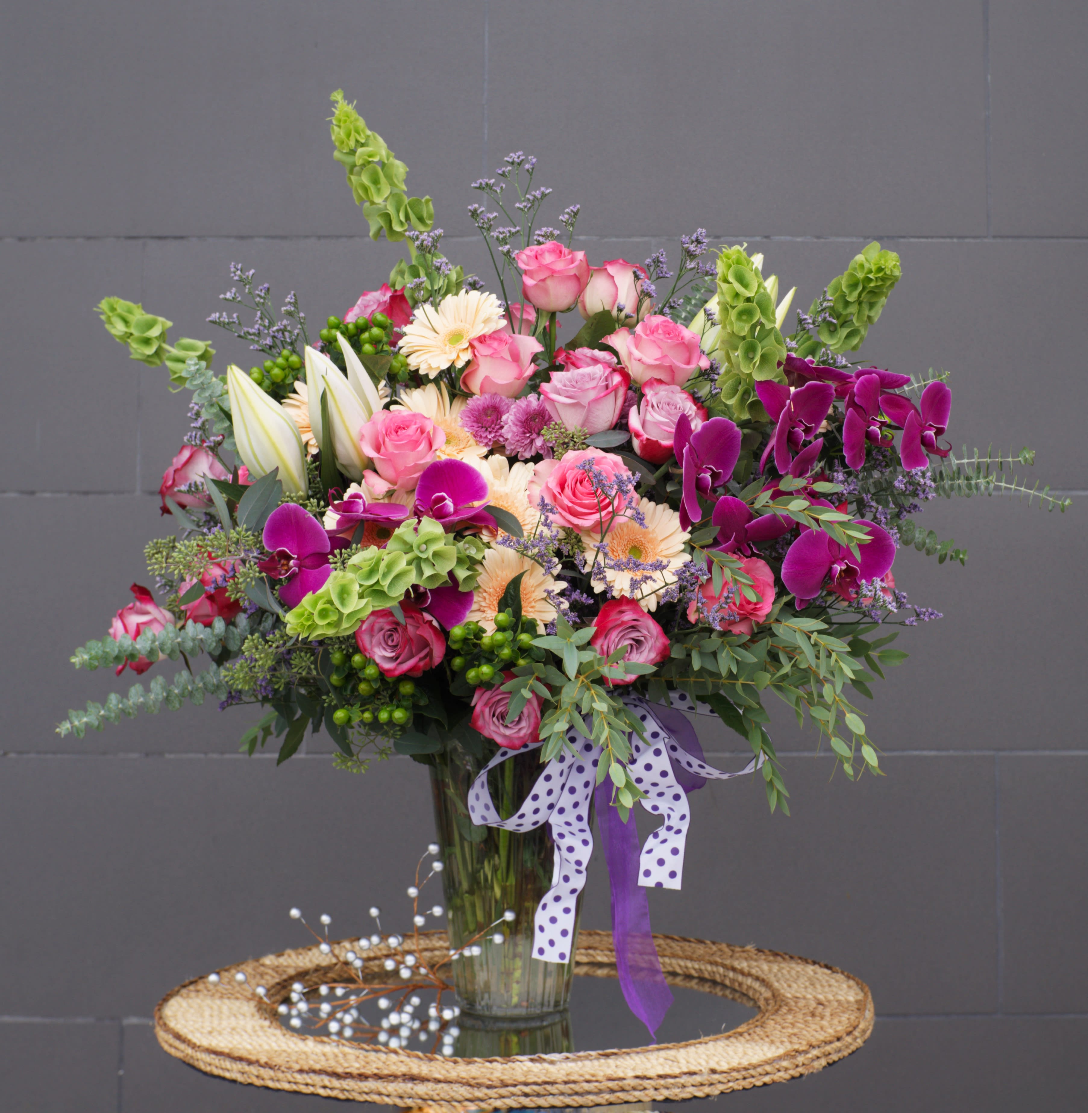 Purple Rain - Beautiful design including all premium fresh flowers: lily, rose, orchid... and nice accents in a tall glass vase. 