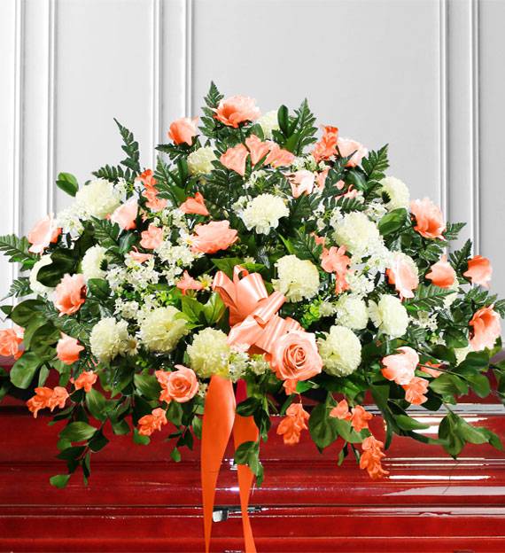 Pastel Peach Casket Spray - This sentiment of peach and white flowers are a peaceful expression of sympathy. We arrange roses, mums and garden style blooms with assorted foliage. 