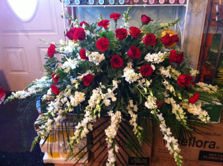 Cherished Casket Spray Cherished Casket Spray - Throughout the years there were many cherished moments. One half-couch casket spray features white stock, snapdragons and dendrobium orchids with a center cluster of red roses and carnations. *Slight Substitutions may be made, but we always fill your order to value and maintain the integrity of the arrangement.