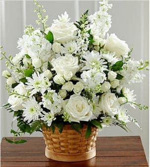 Heartfelt Condolences™ Arrangement - Let this exquisite composition of beautiful white blossoms deliver your sympathy and comfort loved ones grieving a loss. The elegance of this arrangement and its warm, homey basket base makes it an appropriate addition to any wake, funeral or graveside service, or to send to the home of family or friends. Handcrafted by a local FTD artisan florist of individually selected white roses, stock, cushion pompons and larkspur set among complementary greens for a memorable bouquet that evokes a tranquil sense of heavenly hope.  Your purchase includes a complimentary personalized gift message.