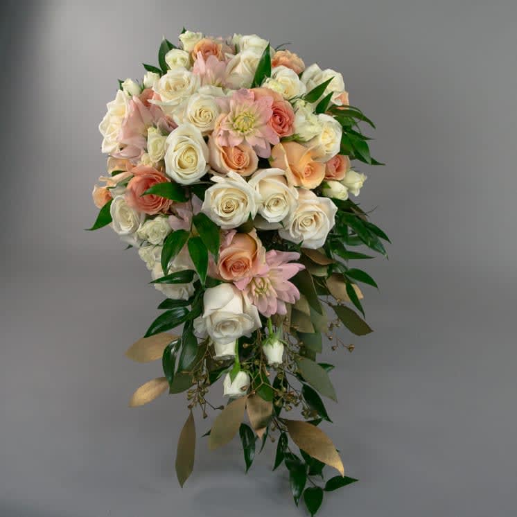 Roses, dahlias, gold leaf accent. - A cascading bridal bouquet of cream roses, white spray roses, peach roses, blush dahlias and a mix of greenery with gold accent. ** ALL BRIDAL MUST BE ORDER 2 WEEKS IN ADVANCE. If there is less than 2 weeks, please contact the design department at 619-295-3444 Ext:103