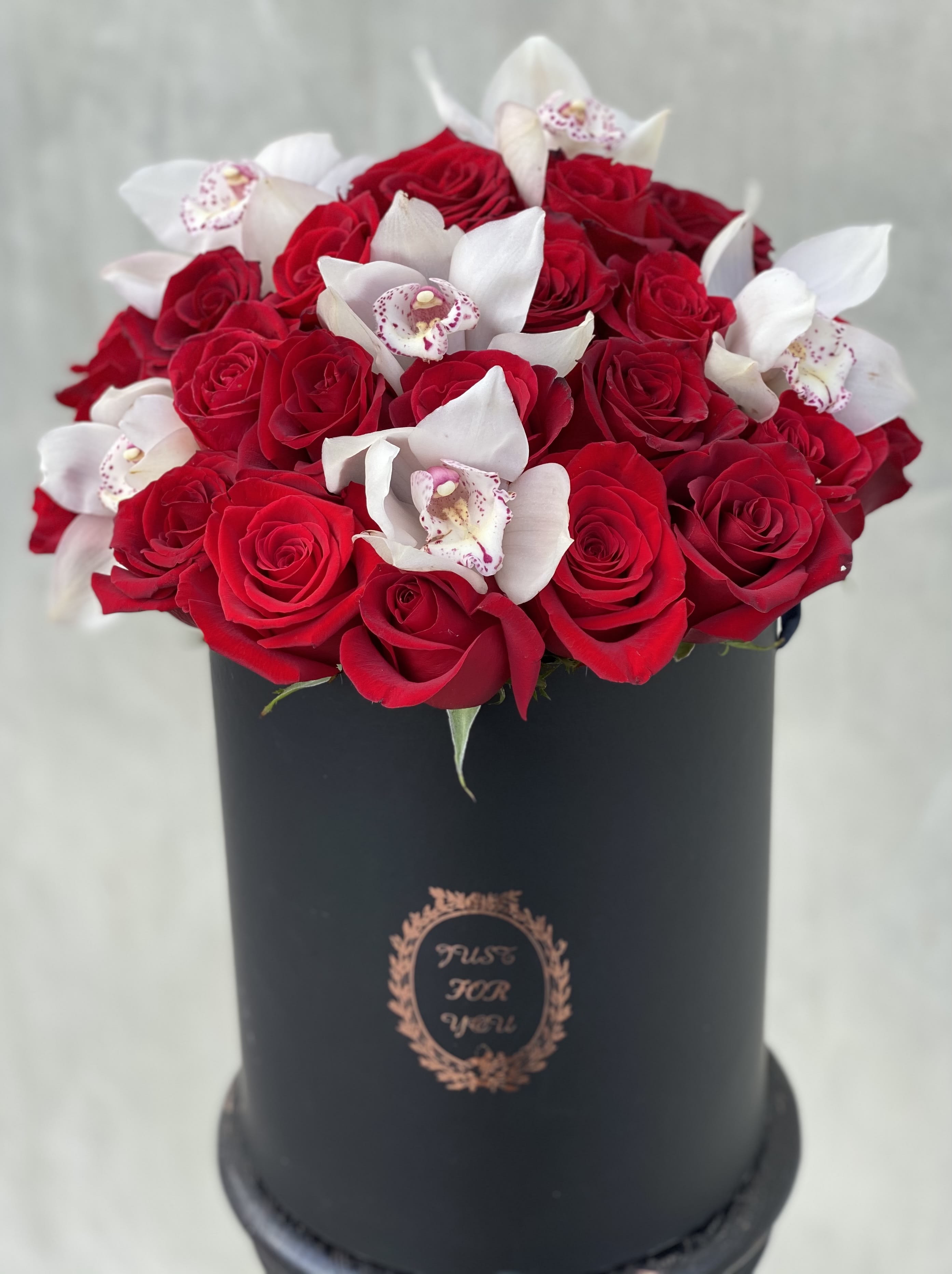 Orchid Treasure Orchid Treasure - Red roses and white Cymbidium orchids in a tall round black box