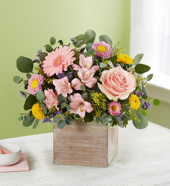 Spring Sentiment™ Bouquet - Spring is a time to refresh and reach out. Our new spring bouquet celebrates that sentiment. Soft pink and yellow blooms are loosely gathered with lush greenery for style and texture. Designed in our rustic, grey-washed wooden cube, it’s a gift that delivers on your feelings in the most beautiful way.