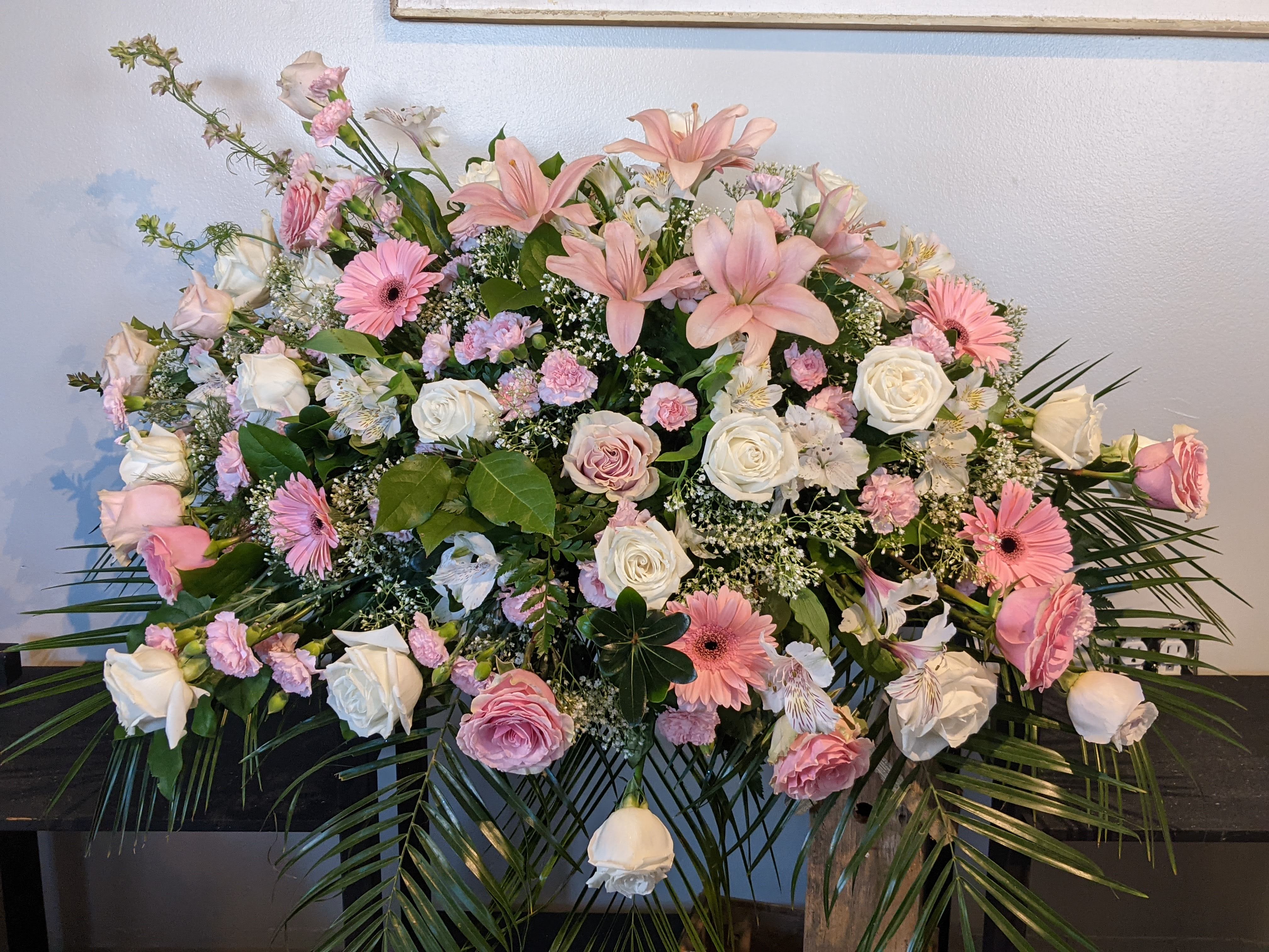 Remembering You Pinks Casket Spray  - A beautiful Casket Spray of pink and white roses, carnations, pink lilies, pink delphinium, gerber daisies and alstro. 