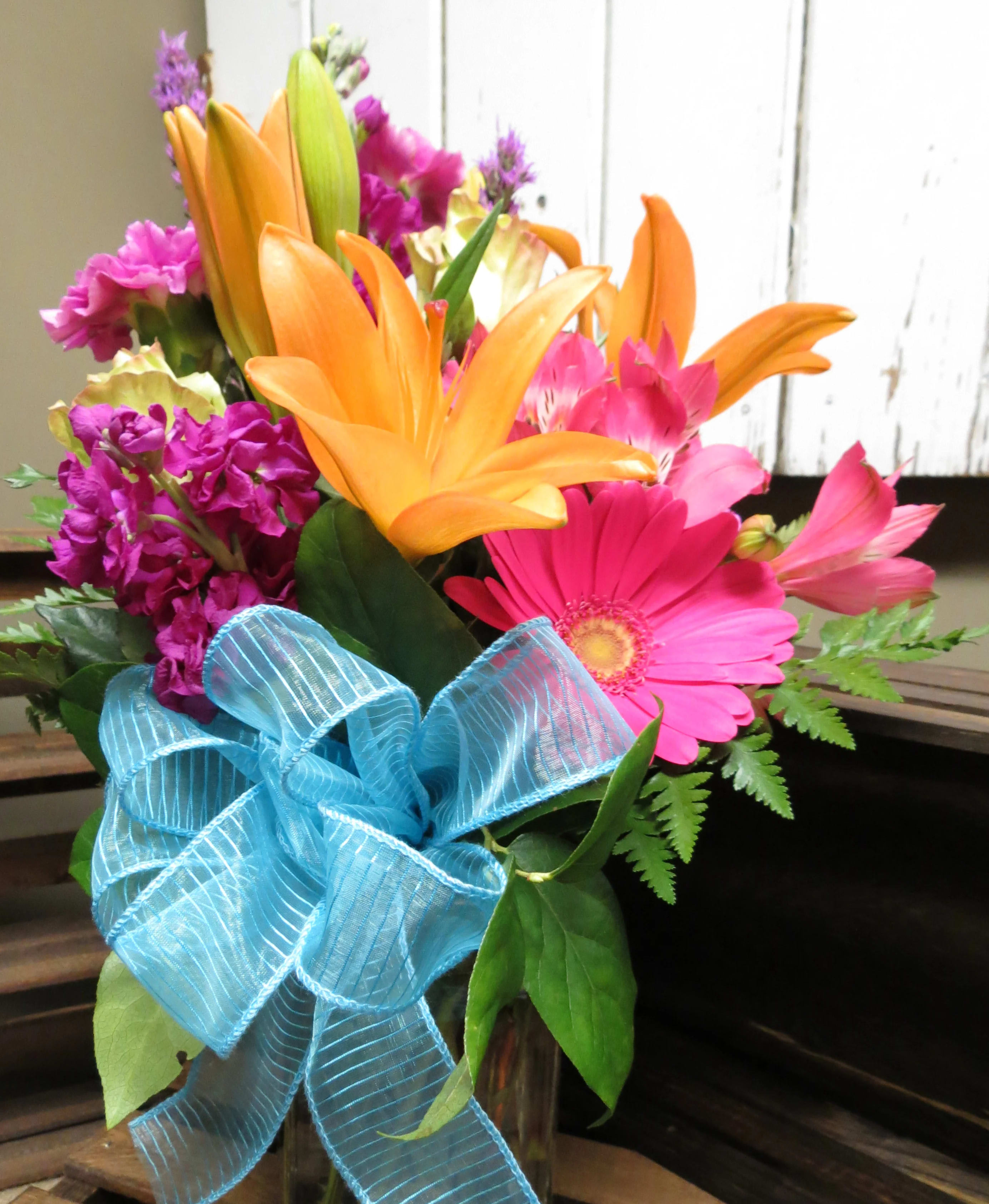 Dreamland - This bright cheerful mix of colorful Lilies, Alstroemeria, daisies, and stock make this vase a go to for any occasion. 