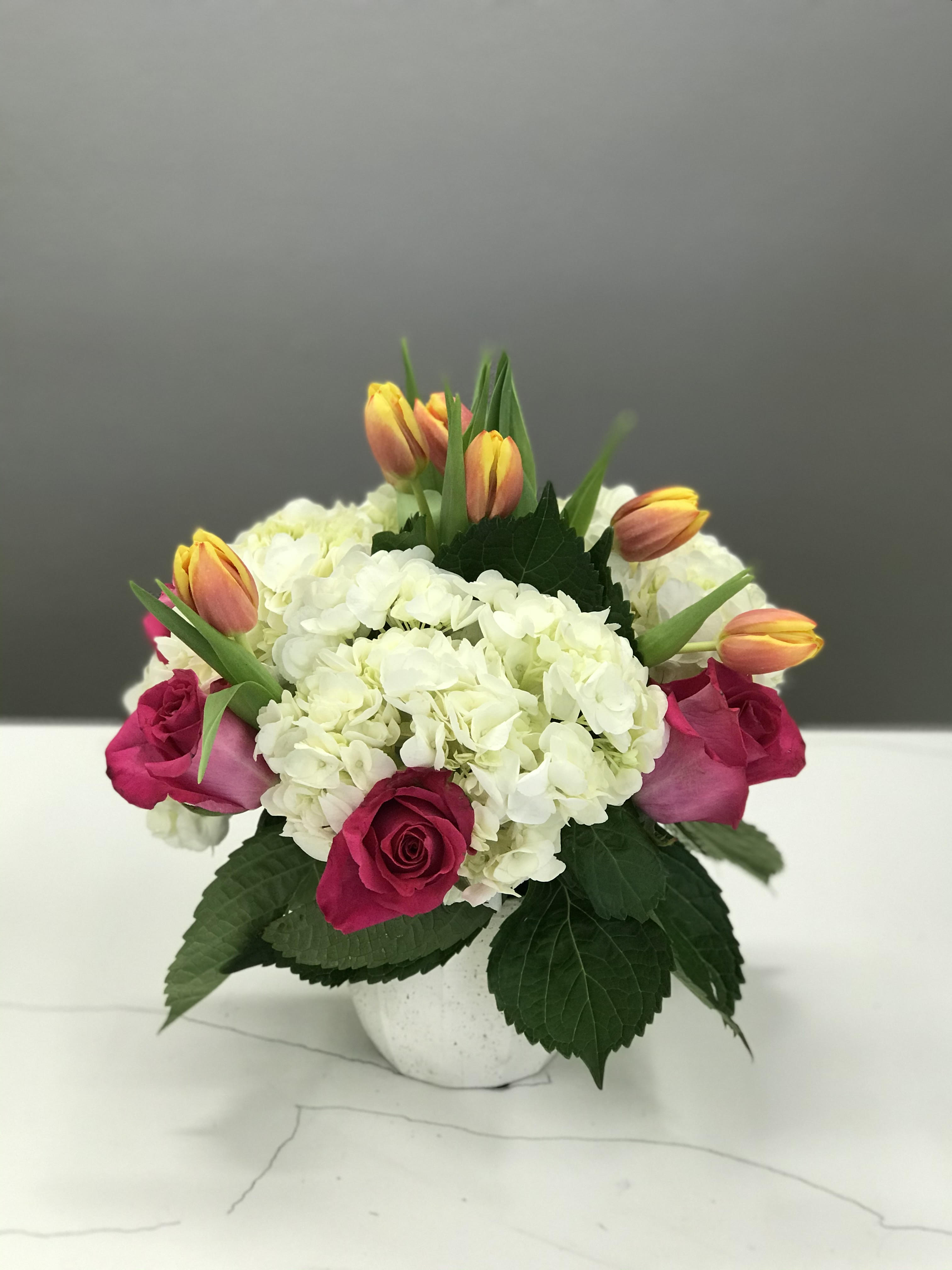 Fun &amp; Flirty by BloomNation™ - This cheerful bouquet brings lighthearted fun to any occasion. Fun &amp; Flirty by BloomNation™ is the perfect gift to wish someone a happy birthday or to say thank you.   Arrangement Details: Includes hot pink roses, pink tulips, and white hydrangea. APPROXIMATE DIMENSIONS: 12&quot; H X 11&quot; W 