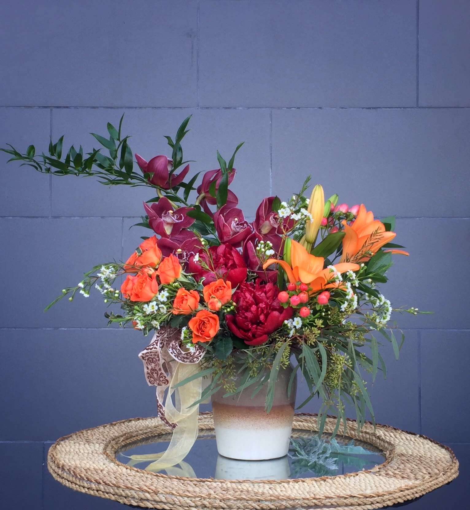 Warm Wishes - Sending warm wishes to people with this design including Cymbidium orchid, rose, lily and accents in a nice container.