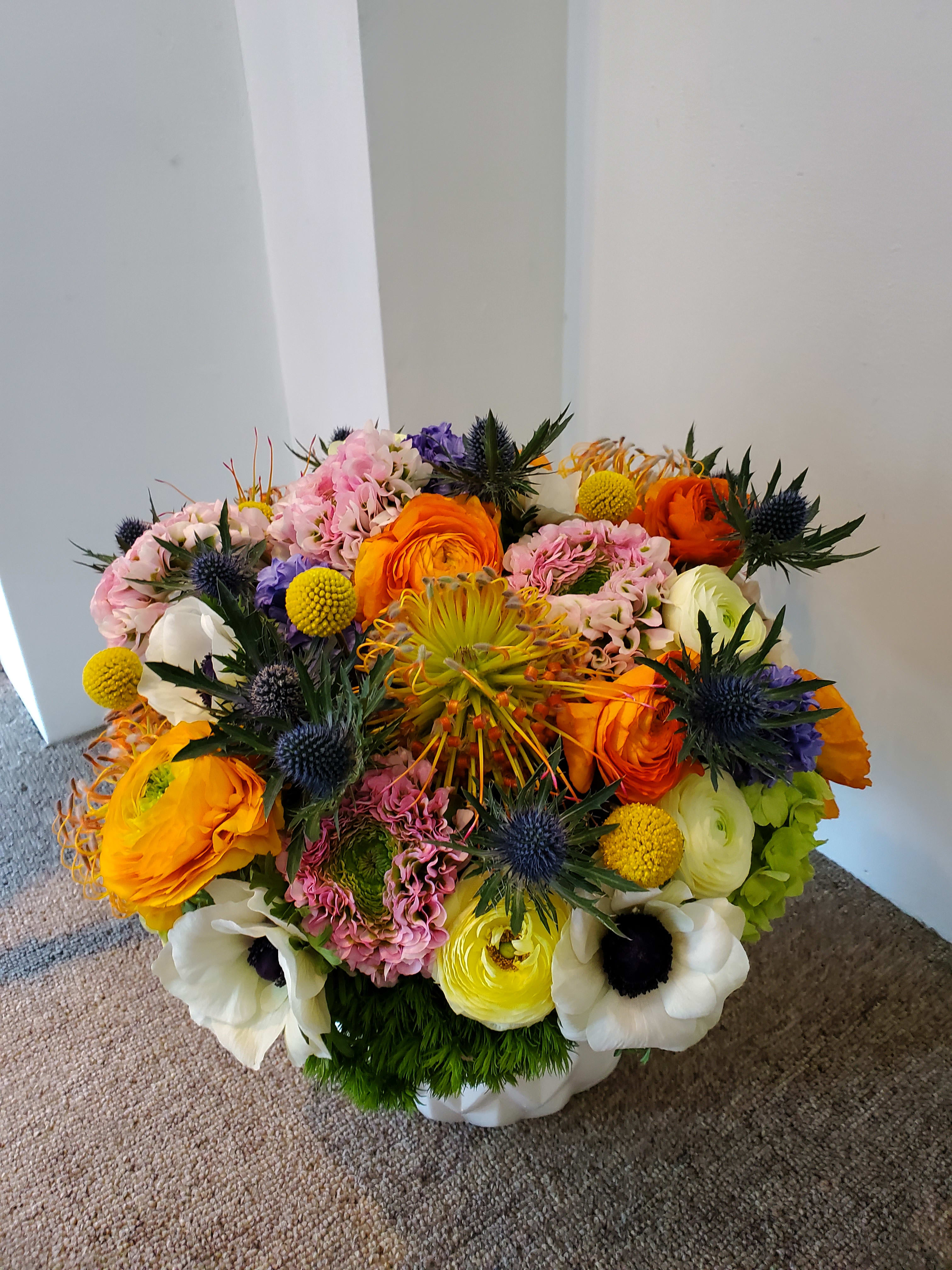 Hydrangeas, ranauculas, proteas, and other colorful flowers - Exciting burst of seasonal flower combination that if one flower is not available they're are so many others to choose from that it keeps its whimsical quirkiness.  