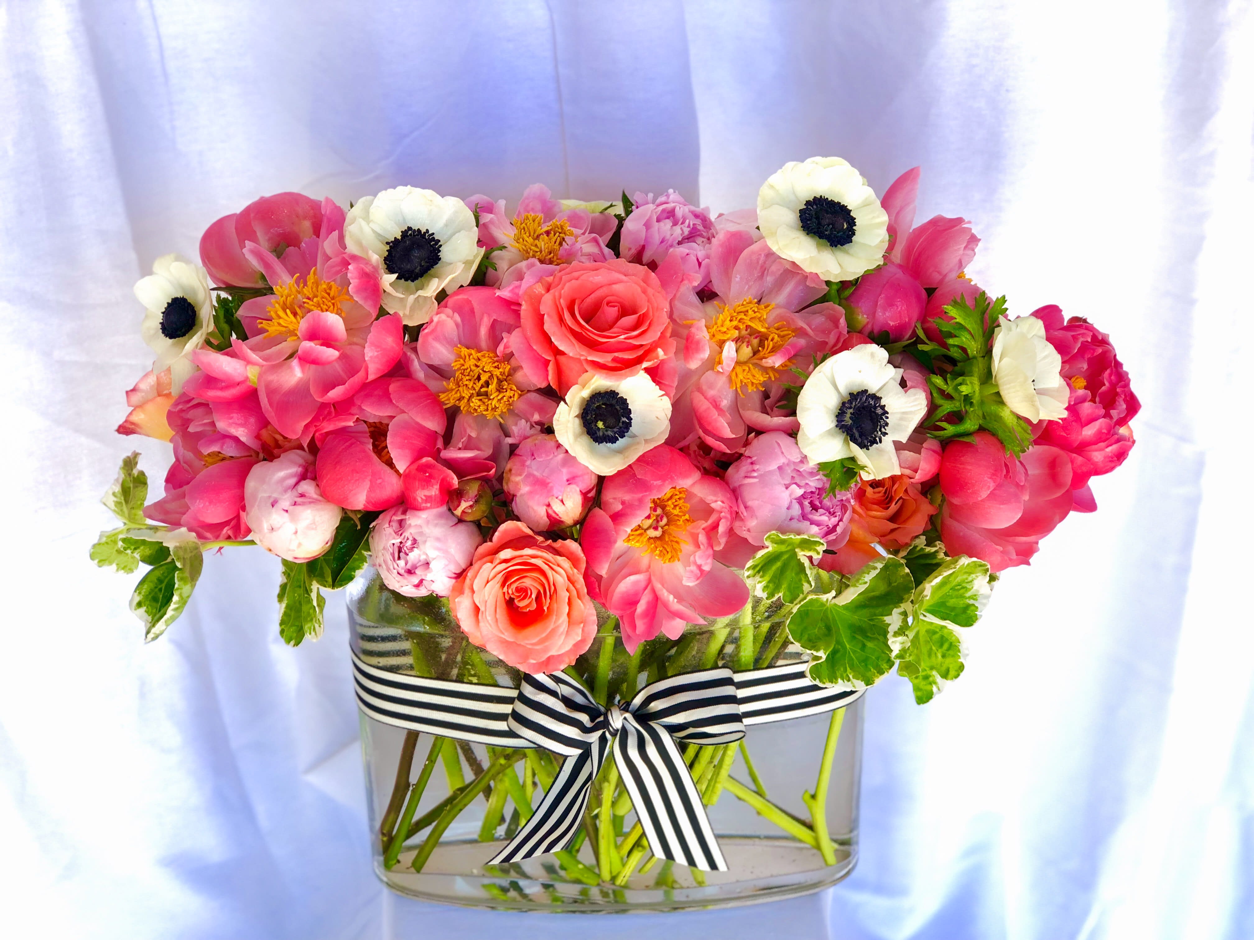 The Showstopper - A stunning, lush arrangement that is overflowing with peonies, garden roses, anemones, and other seasonal fluffy blooms. This oversized arrangement is a show stopper, and is sure to be the brightest star in the room. It's big, trust us!!! Seasonal availability on peonies is limited, please inquire about available blooms.