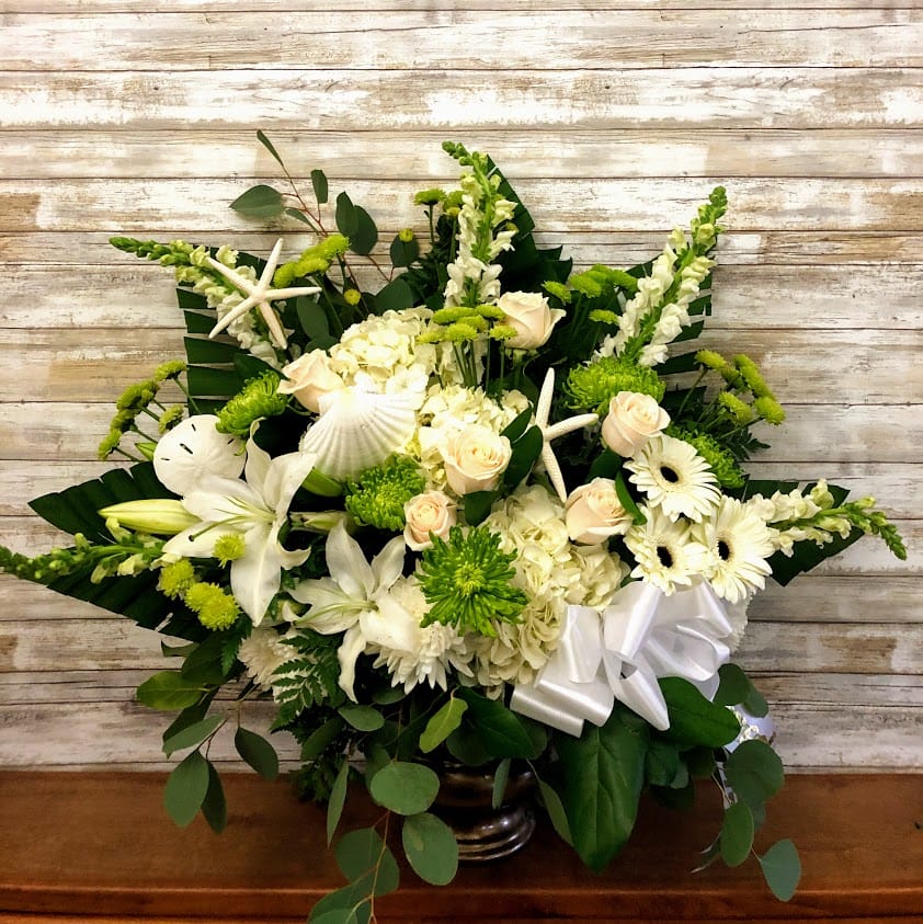Green and White Coastal Tribute Green and White Coastal Tribute - Honor your Loved one with this beautiful basket arrangement filled with green and white blooms and accented with starfish and shells. Approx. 30" tall