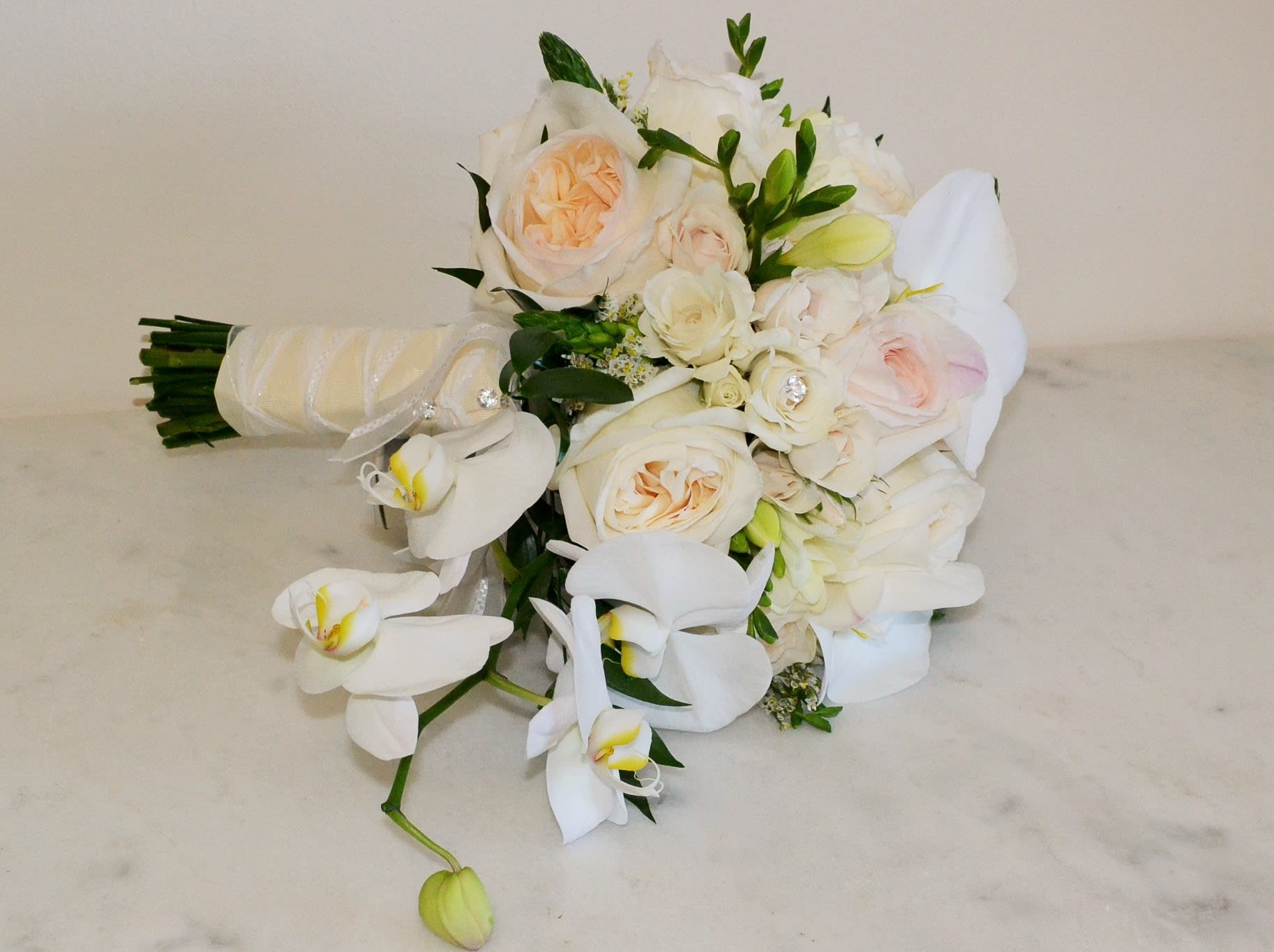 White handwrapped bouquet - beautiful hand wrapped bouquet with garden roses and orchids.  Flowers and similar colors