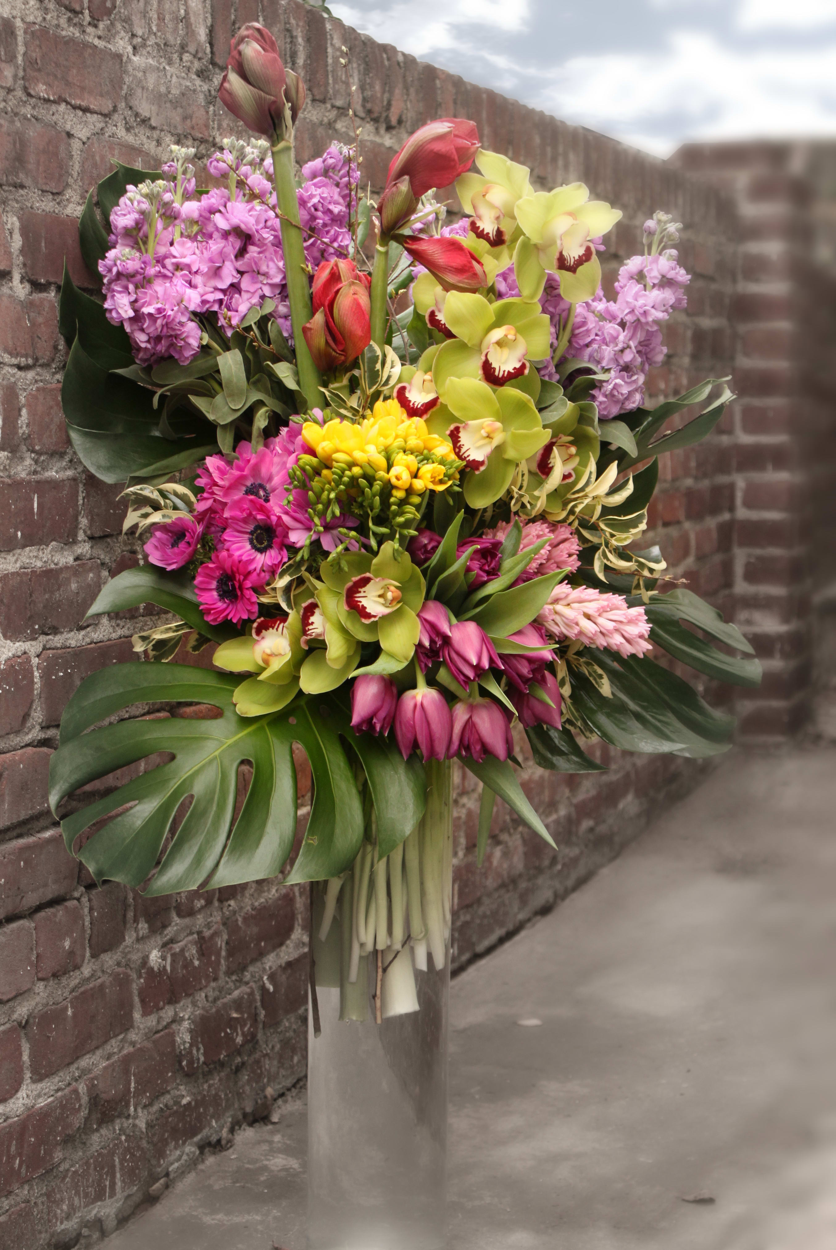 Explosion of Spring Colors - Extravegent arrangement of  Orchids, Amarillas, Tulips, Freesias and Anemonies in a glass vase. This grandiose design makes an amazing gift for Mother's Day, anniverseries, birthdays and other major events. Approx. 40&quot; Tall X 20&quot; Wide
