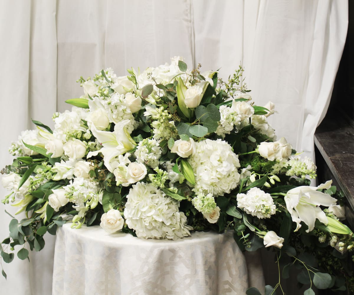 In Peace - Thoughts and prayers of tranquility for a loved one.   Key notes for this design are white flowers and a casket spray.