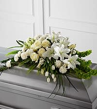 The FTD® Resurrection™ Casket Spray - The FTD® Resurrection™ Casket Spray inspires thoughts of comfort and peace to those wishing to pay their respects for the loss of the deceased. White tulips, roses, snapdragons, Oriental lilies, larkspur, carnations and Monte Casino asters are accented by the bright green stems of Bells of Ireland and an assortment of the finest lush greens to create the perfect arrangement to display on the top of their casket during their final farewell service.