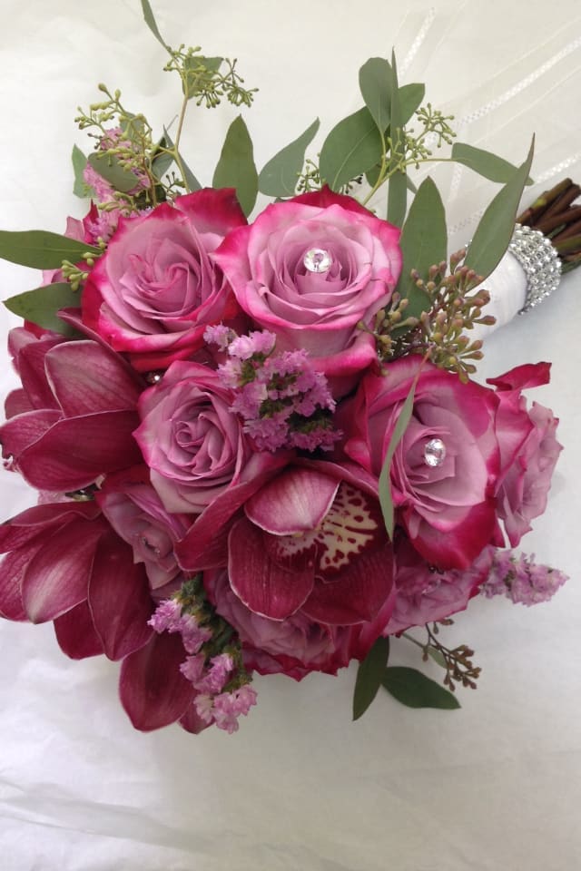Hot pink wrapped bouquet - hot pink roses with pink cybidiums wrapped with satin ribbon.  Flowers and similar colors