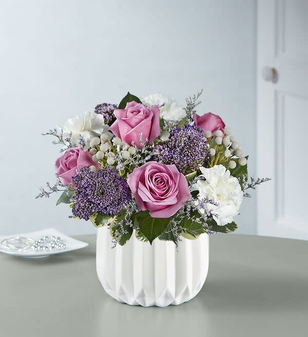 Charm and Bliss Charm and Bliss - A bouquet that dances by the light of the moon. Inspired by the hues of a moonbeam, our modern arrangement is crafted of blue & white blooms. It’s designed inside our white ceramic geometric vase with satin finish for an enchanting complement.