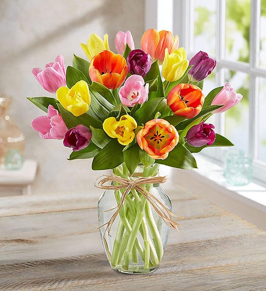 Timeless Tulips - Cheerful tulips are nature’s way of saying, Spring is here! Our timeless bouquet is filled with these feel-good blooms in a bunch of bright colors. Gathered in a clear glass vase finished with a raffia bow, it’s an everyday gift of instant happiness