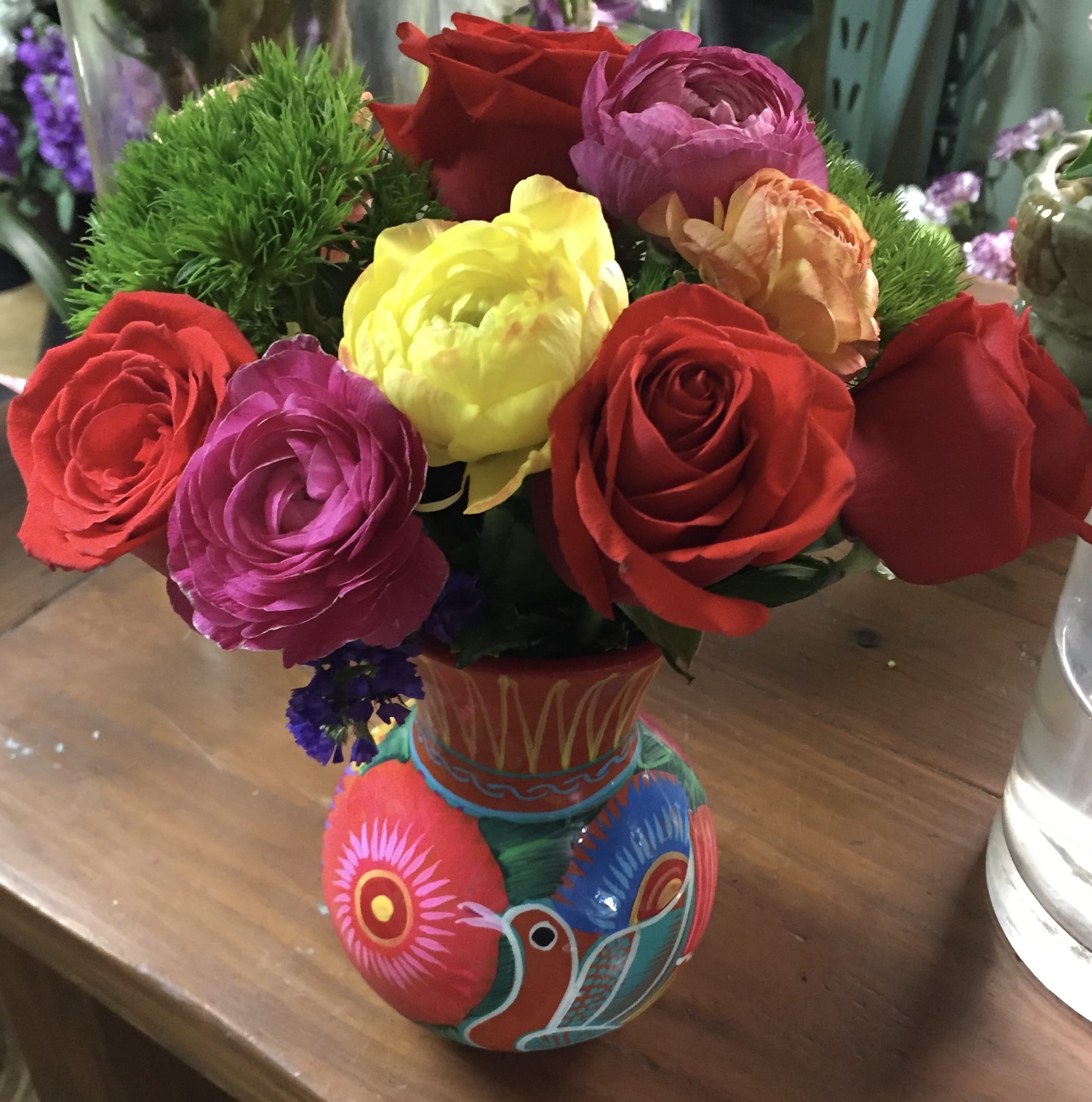 Artful Arrangement Artful Arrangement - Roses, ranunculus, all placed in Hand made -Mexican folk art vase