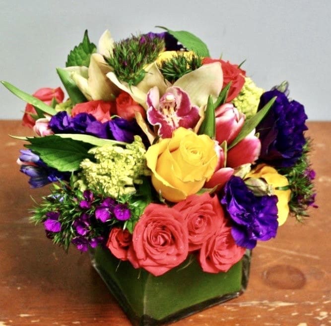 Luminous Blossom Luminous Blossom - This arrangement contains yellow roses, pink roses, pink tulips, purple lisianthus, and dianthus all arranged in a glass vase.