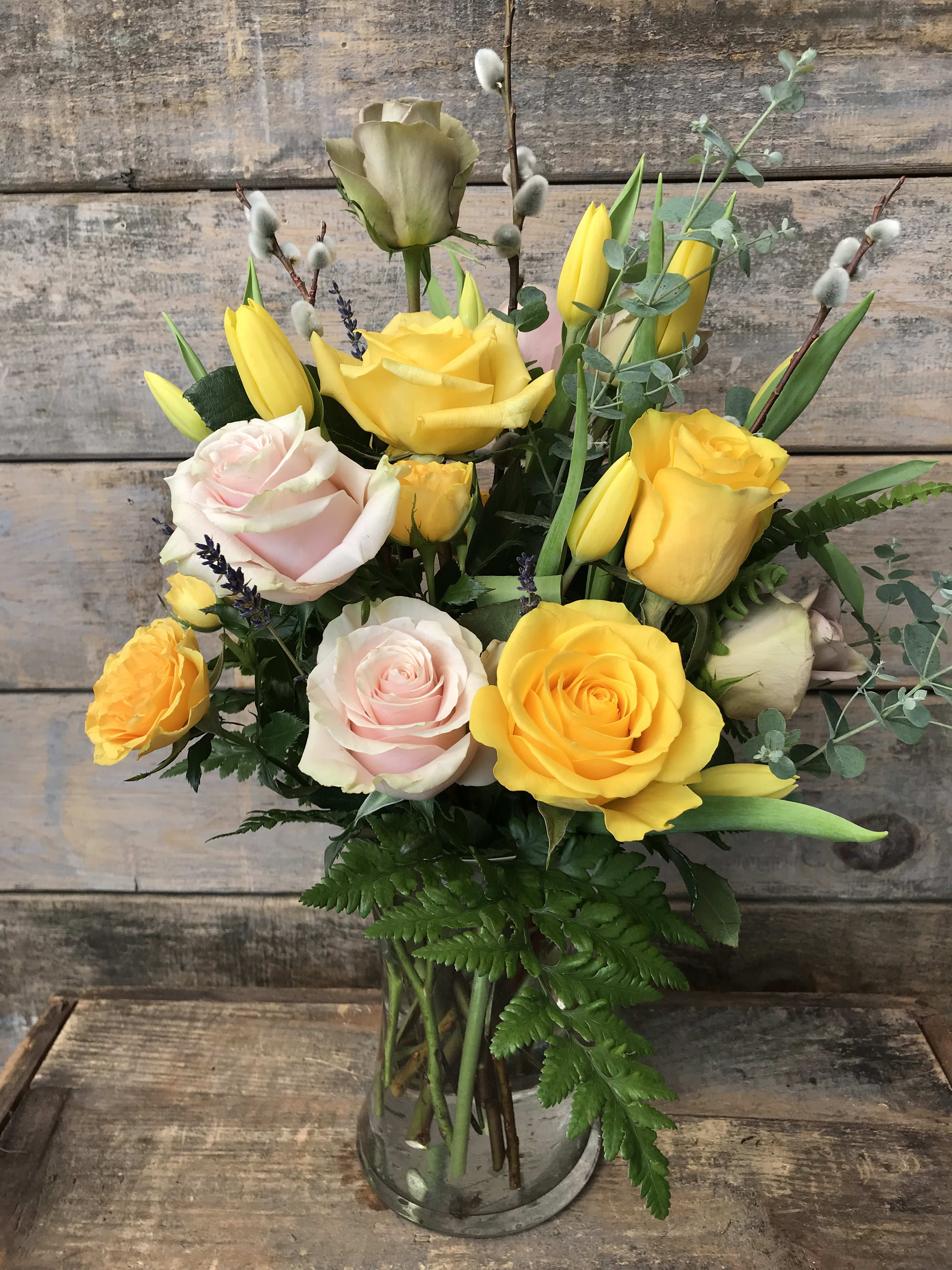 Blooms for Spring in Yellow - Our artisan handmade arrangement's overall theme is shades of yellow. The actual bouquet or arrangement may not precisely match the photo, but its temperament will. The freshest, artisan flowers available are used to create an exquisite arrangement especially for you. We also use a variety of unusual greenery for an example eucalyptus, salal (lemon leaf), pittisporum. Occasionally, substitutions of flowers or containers happen due to weather, seasonality and market conditions which may affect availability. If this is the case with the gift you've selected,we will ensure that the style, theme and color scheme of your arrangement is preserved and will only substitute items of equal or higher value.