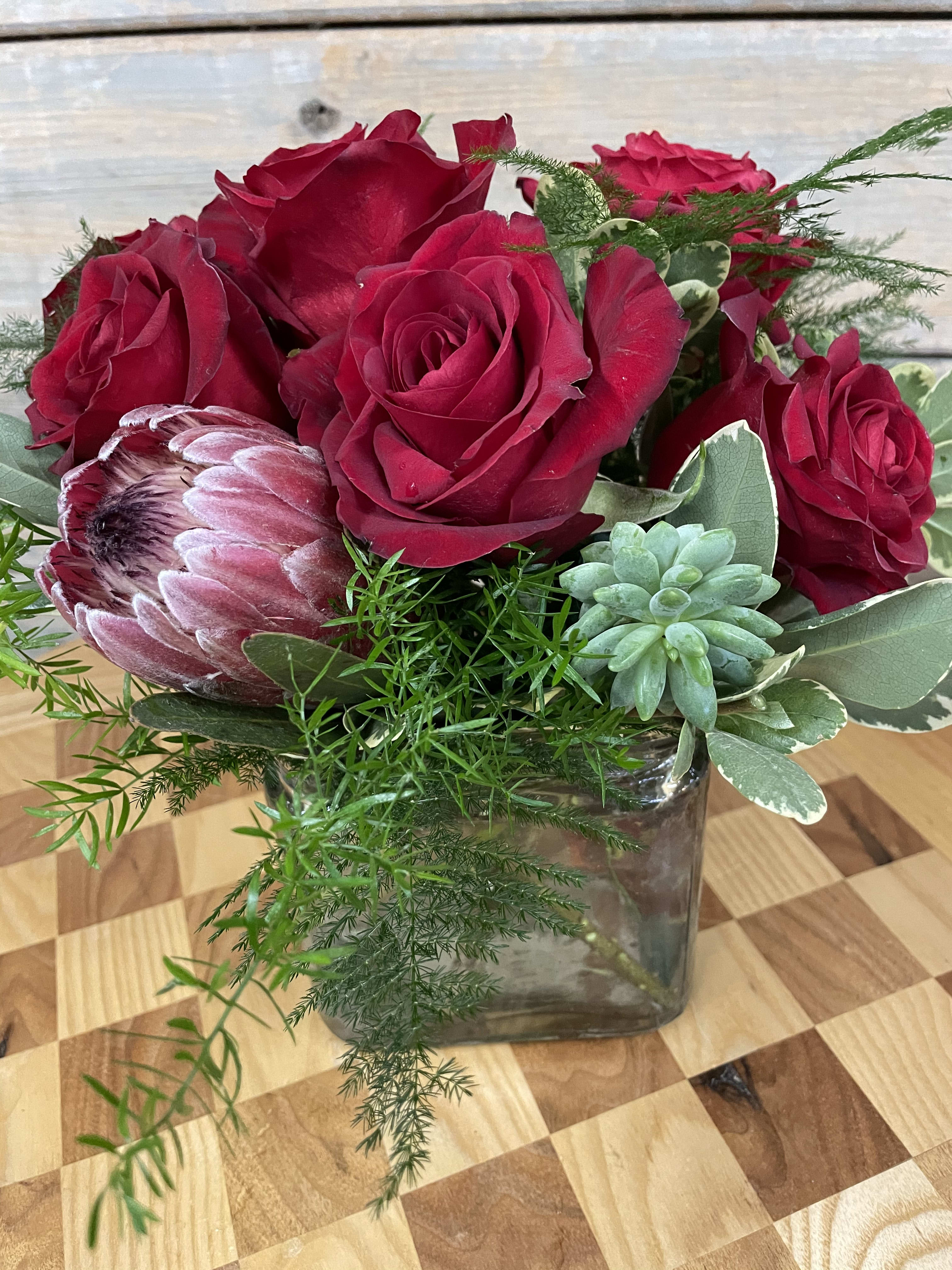 Tropical Red - Protea, Succulents, half a dozen Red roses, and an interesting selection of greens. 
