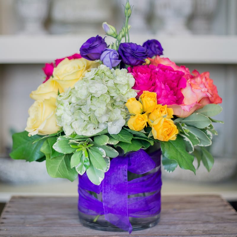Majestic Beauty - Bright mixed flowers in a short compact cylinder.