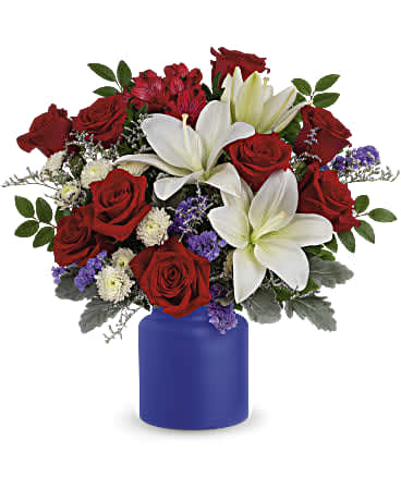 Rose Revelry Bouquet - Revel in the crisp, classic color scheme of pristine white lilies and radiant red roses, presented in a cobalt-hued, frosted glass jar.