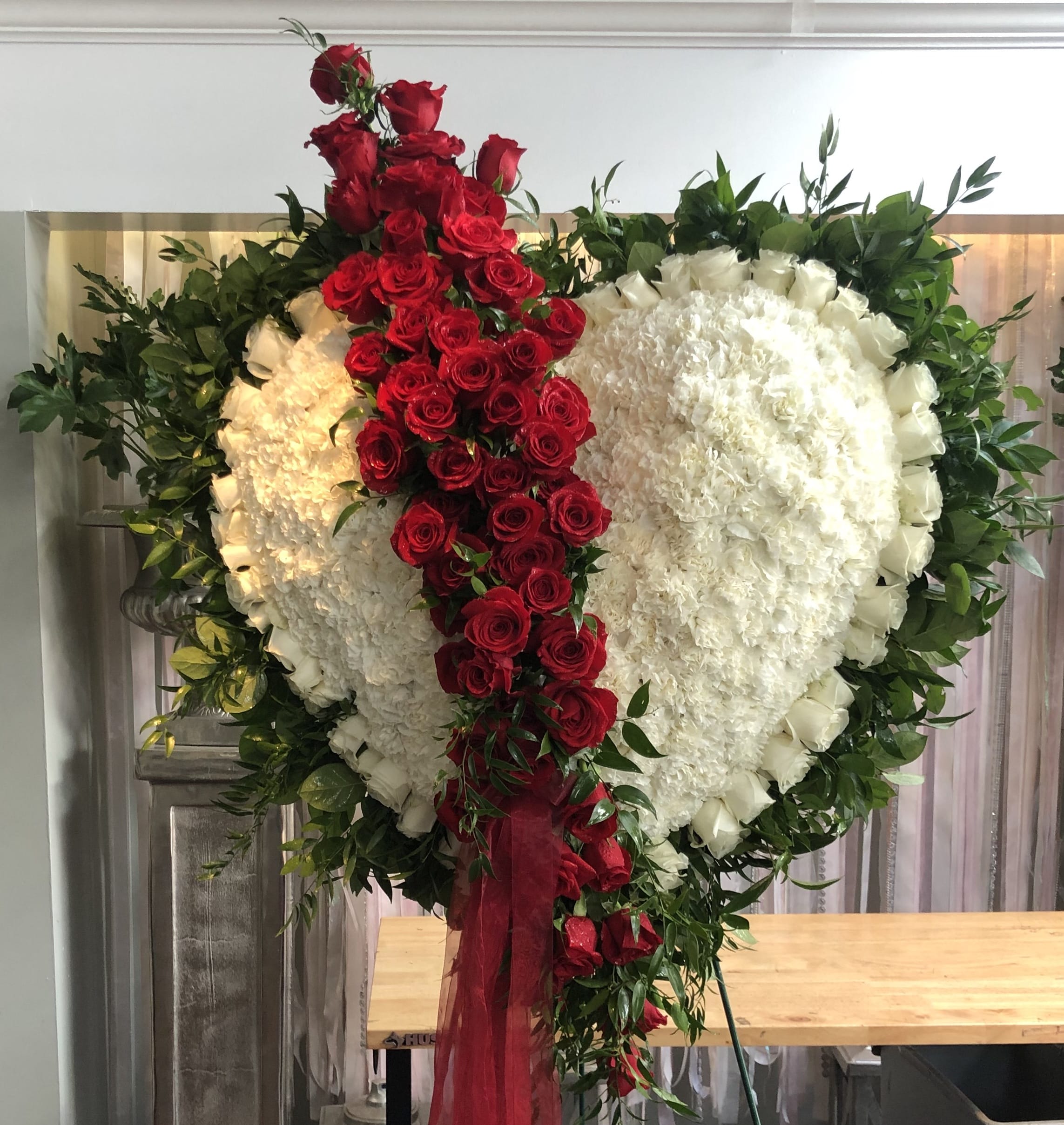 White Sympathy Heart with White Rose Border and Red Rose Break - The traditional bleeding heart is a beautiful display expressing your profound affection for your loved one. This large beveled heart is designed with white roses and a red rose border and break. 
