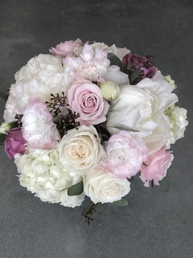 Precision Precision - Mix of seasonal flowers with soft pastel hues, arranged in a clear glass vase.