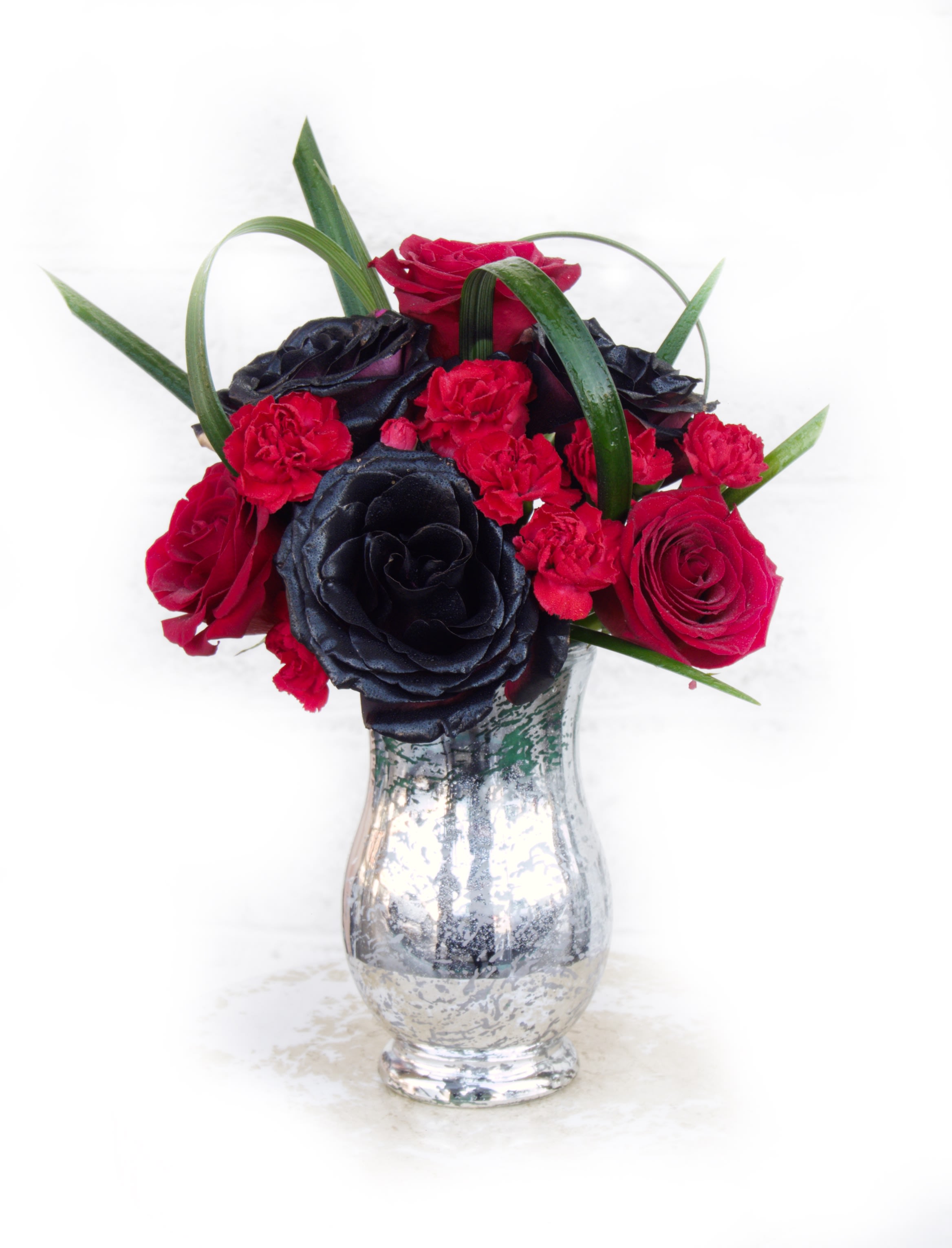 Dare To Love - Classy black and red, this design includes Ecuadorian roses and accents in a silver vase. STANDARD: 3 BLACK ROSES + 3 RED ROSES DELUXE: 6 BLACK ROSES+ 6 RED ROSES PREMIUM: 12 BLACK ROSES: 12 RED ROSES