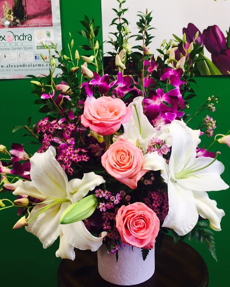 Purple, Pink and White Floral design  - Perfect Arrangement for Orchid Lovers ! Purple Orchid, Pink roses and White lily flower arrangement. We used our special Ecuadorian hermosa pink Roses ,white Casa Blanca Lilies with Purple orchids in a elegant design. You are going to love this Bouquet. Perfect Flower Bouquet for your special person. Beautifully designed with 8 orchids, 3 roses , 4 White Lily blooms and Other Seasonal Flowers. Pick this purple, pink and white flower Bouquet for Mother's day, Valentine's Day, Anniversary wishes, Birthday Wishes or may be just because you love some one so much. This gorgeous Arrangement comes in a designer choice elegant pot. You can get 10 Orchids by Upgrading to deluxe and Premium with 10 Orchids and 5 Roses. Call for special Request. Send this spectacular Rose bouquet now !  Our Floral designer might discuss with you about the design or color depends on the availability of certain flowers. We promise to make the best floral design every time for your special reason.  Garden of Roses is the Best Local florist in Moreno Valley and Surrounding areas. We won the Best Flower Shop Award in 2013 out of 30 florists in Inland Empire, CA. This Flower Arrangement will bring Smile to your loved ones, and we promise to provide the best Flower Delivery Service you ever have. We are not an Online Flower Delivery Services, We are real local florist! We will create a stunning bouquet and hand deliver the Arrangement on your special occasion to your special person. Send this Stunning Rose Bouquet for Anniversary Wishes, Birthday Wishes, Just Because Flowers, Thinking of You Flowers, Miss you flowers, Valentine’s Day Flowers, Mothers Day Flowers. 