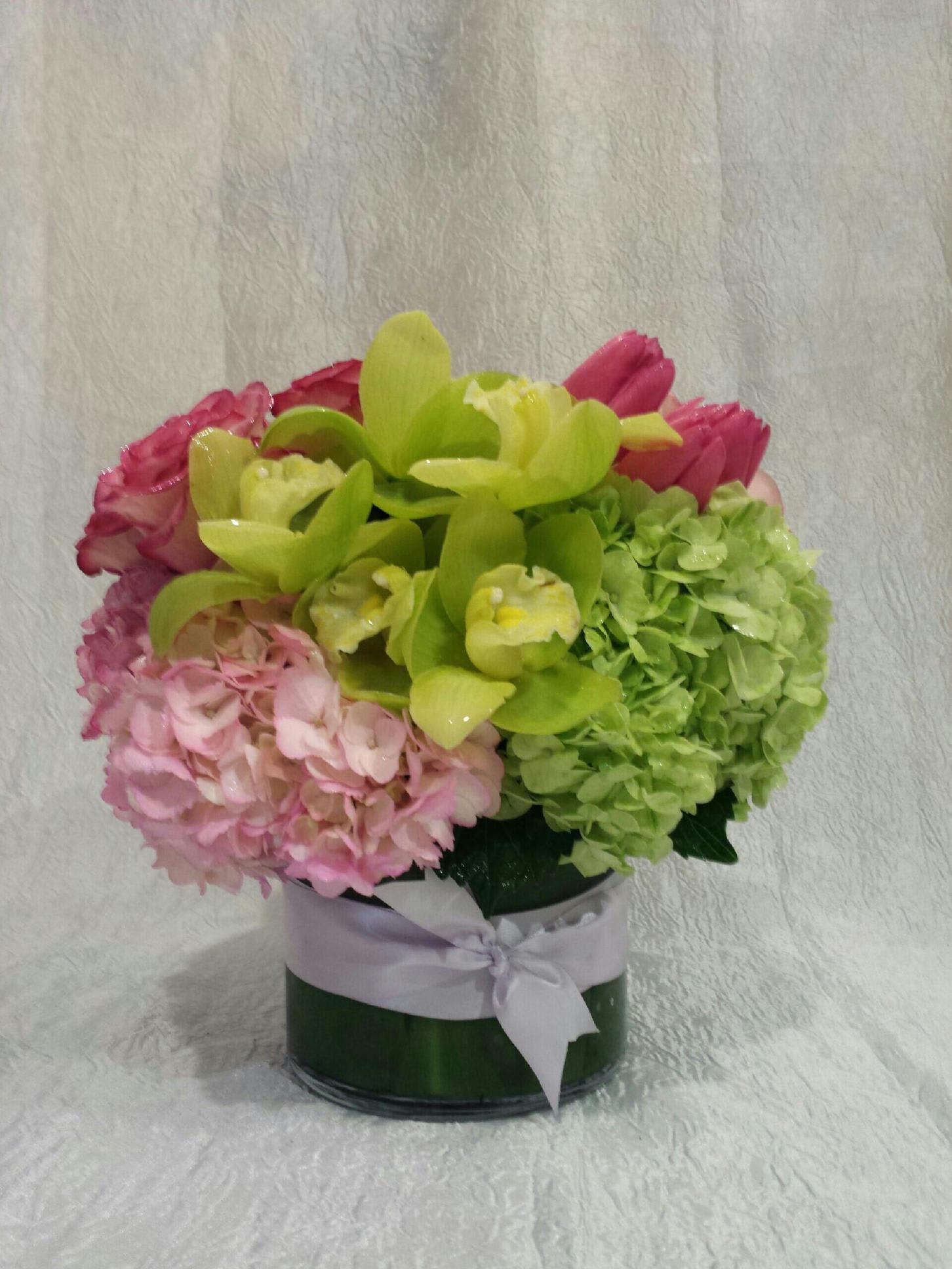 Garden Forever - Low and round arrangement composed of hydrangeas, roses, tulips and cymbidium orchids for an elegant touch.