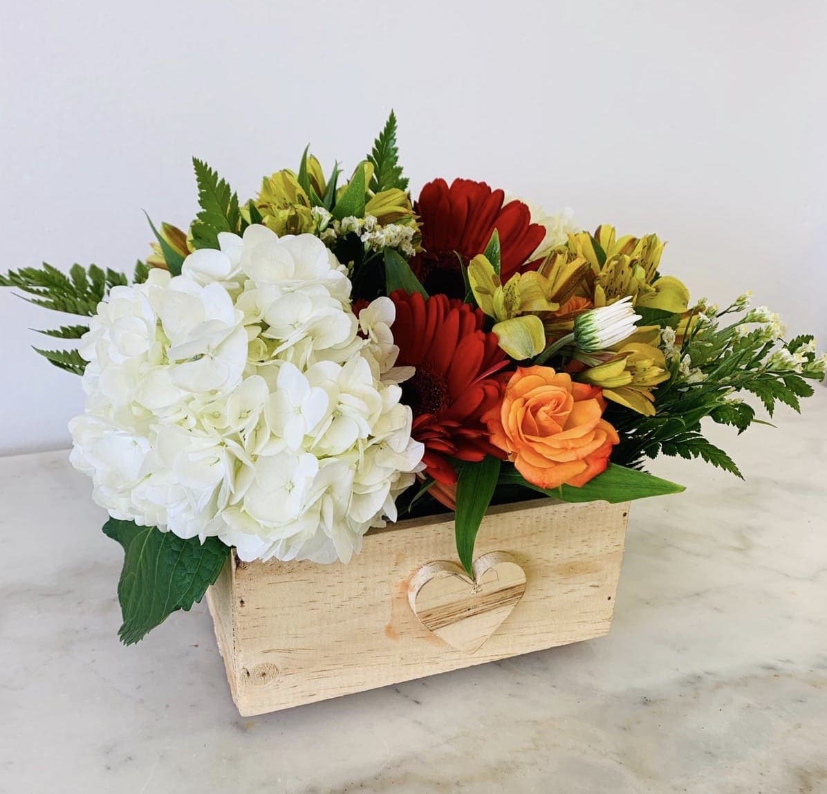 Garden Box  - An arrangement of natures finets red gerberas, white hyndrangea, yellow alstromelias and orange spray roses in a wood box. 