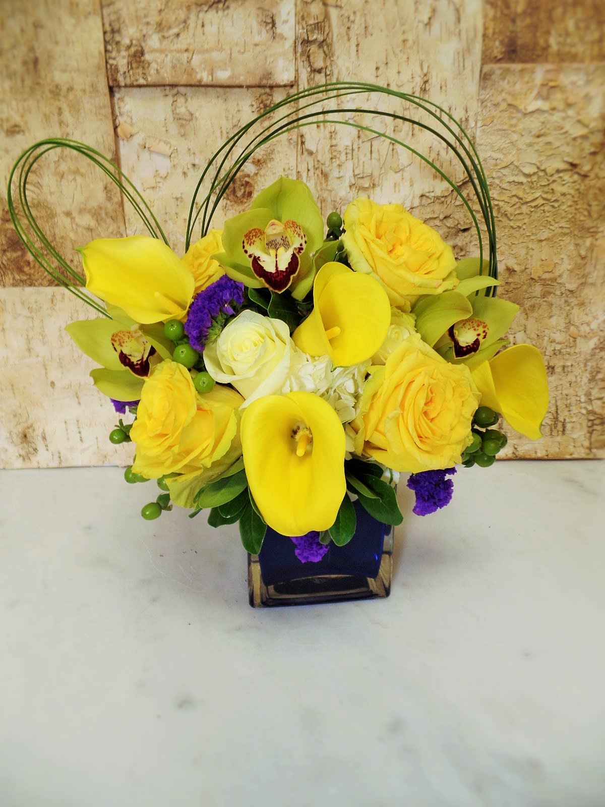 Yellow and Blue Yellow and Blue - Beautiful blue crystal vase with yellow roses, callas and orchids, A perfect modern design for any occasion.