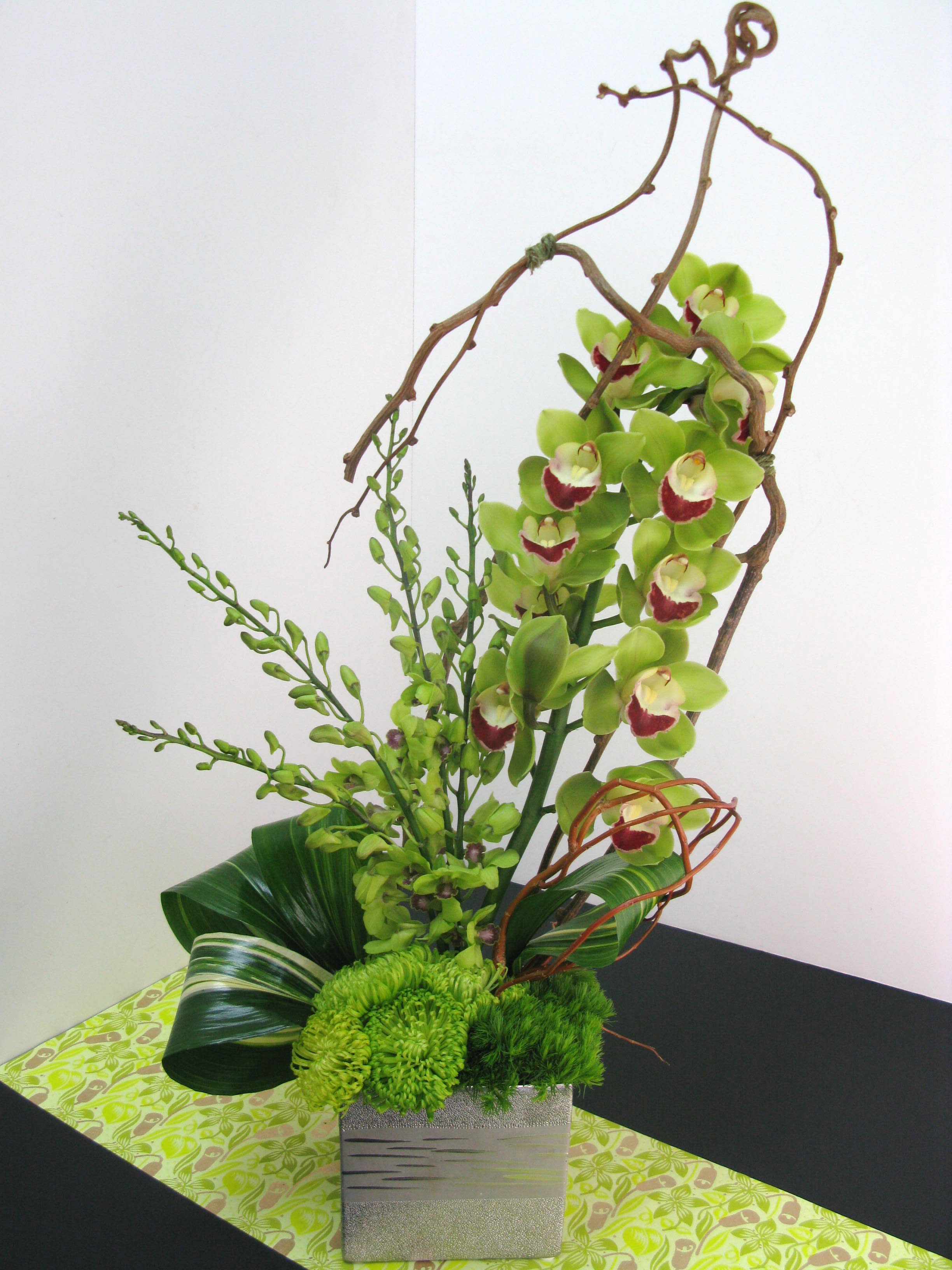 GreenDreams - Orchids are a good way of sharing a peaceful and humble feeling. This arrangement contains cybidium orchids with lots of green to bring the calm vibe to any place.