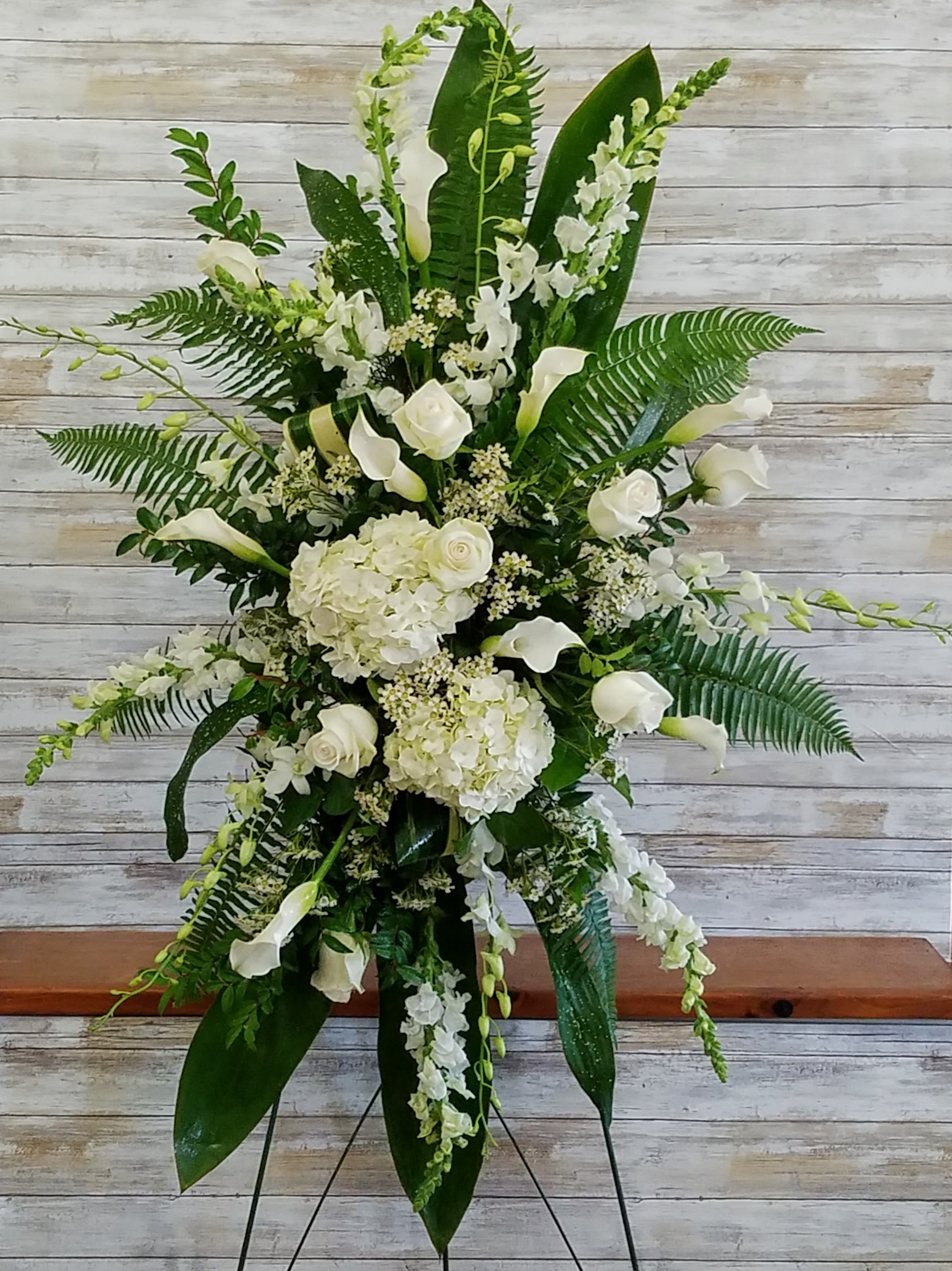 Peace and Grace Spray  - An elegant expression of sympathy, this wondrous white and green spray conveys purity and peace. A glorious choice for a magnificent memorial including Hydrangea, Orchids, Calla Lilies, Snapdragons, Roses and Aspidistra leaves.  