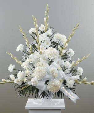 Joyful Spirit - A graceful pedestal arrangement of all whites featuring gladiolas, carnations, chrysanthemums and cushions to create a display of warmth and caring for the service. Complimenting bow included. (Scripting not included).