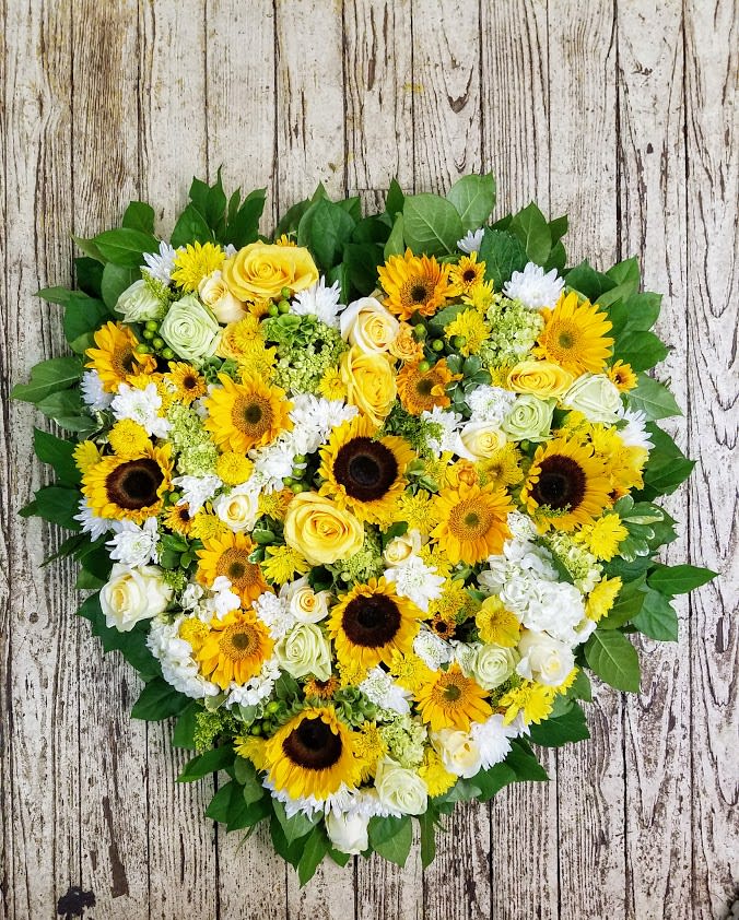 Sunshine Heart Sunshine Heart - 24" Solid Heart arranged with suflowers, hydrangea, roses, berries, mums and accented with solidago and greenery. Smaller Size Available Call for Pricing