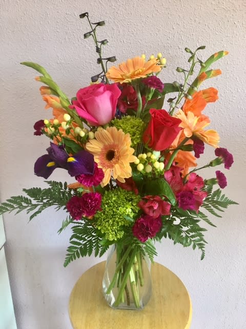 Welcome Home By Forever Flowers - Surprise your neighbors with something that will create an everlasting bond between the people that will live life alongside you with orange Gladiolas and Gerberas, pink Roses and Carnations, and luscious purple Iris.