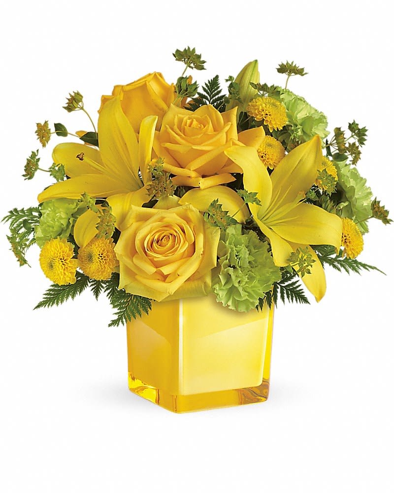 Teleflora's Sunny Mood Bouquet - An instant pick-me-up! Beautifully arranged in a stylish cube vase these radiant roses and lilies deliver smiles and sunshine any day of the week. This bright bouquet includes yellow roses yellow asiatic lilies green carnations yellow button spray chrysanthemums bupleurum and leatherleaf fern. Delivered in a glass cube.Approximately 13 1/2&quot; W x 13&quot; H