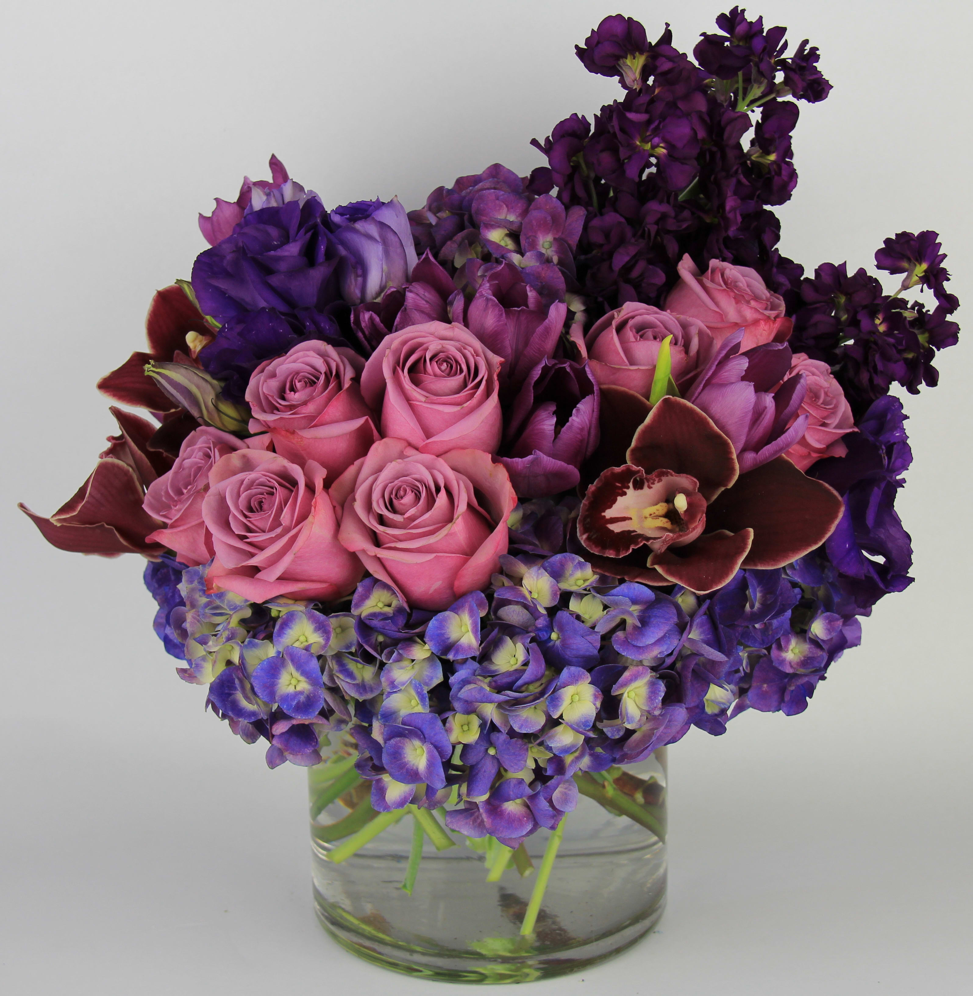 Enchanted Purple Enchanted Purple - Enchanted purple is made with purple roses, deep purple hydrangeas, tulips, lisianthus, and exotic cymbidium orchids.